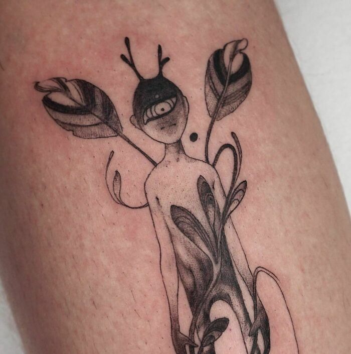 Abstract nature tattoo design on skin, featuring a human figure intertwined with plant elements.