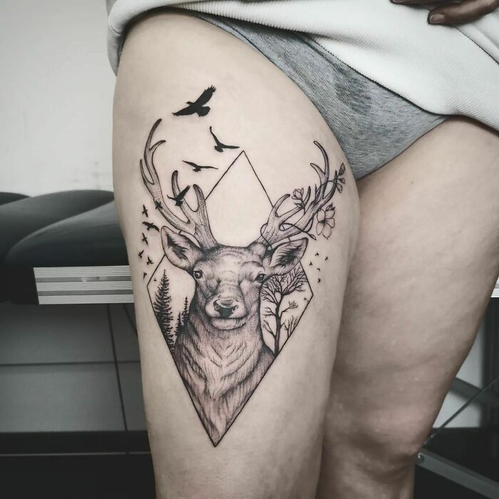 Nature tattoo featuring a deer with antlers, birds, and trees, symbolizing the beauty of Mother Earth.