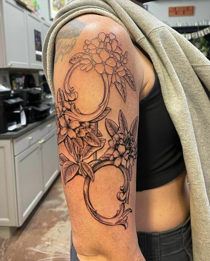Nature tattoo on arm featuring detailed floral design, celebrating the human-earth bond.