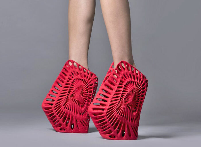 Red geometric weird shoes with intricate cut-out patterns, showcasing unique fashion footwear design.