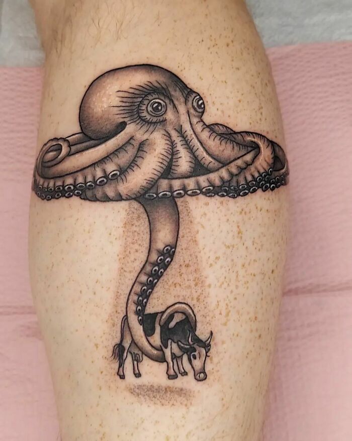 Octopus and cow nature tattoo symbolizing human-earth bond, inked on leg skin.
