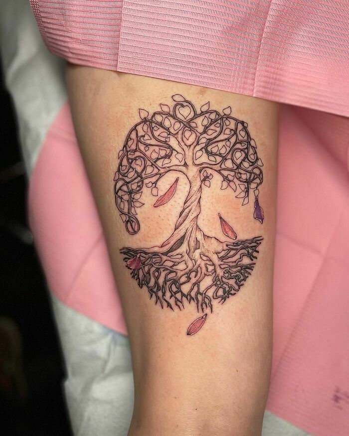 Tree tattoo symbolizing human-earth bond with intricate roots and branches on arm.