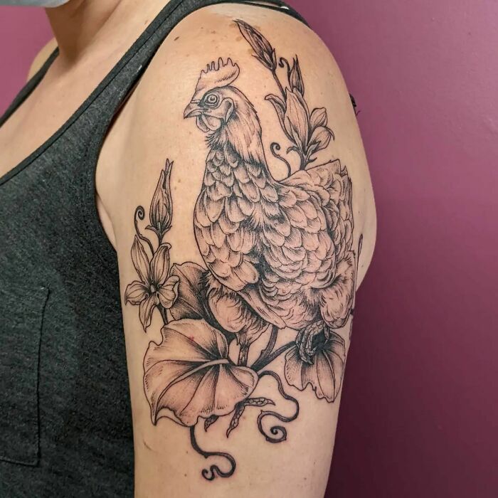 Nature tattoo of a rooster with flowers on an arm, celebrating the wonders of Mother Earth.