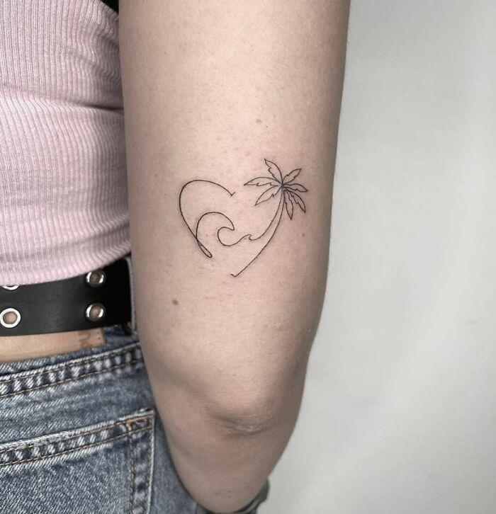 Single-line tattoo of a wave and palm tree on an arm, showcasing minimalist design.
