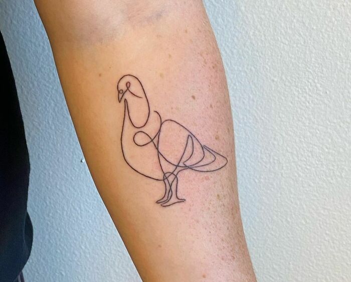 Single-line tattoo of a bird on an arm, showcasing elegant and minimalist design.