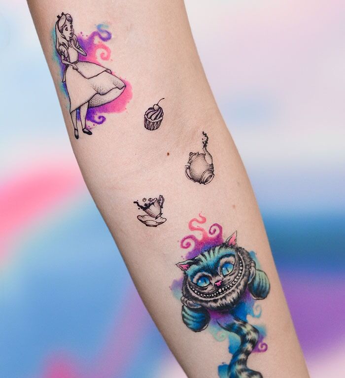 Watercolor tattoos depicting whimsical characters and vibrant colors on an arm.