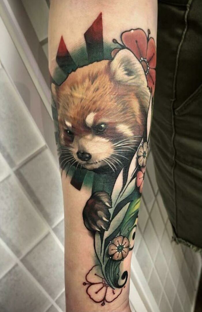 Colorful animal tattoo of a red panda with flowers on a forearm.