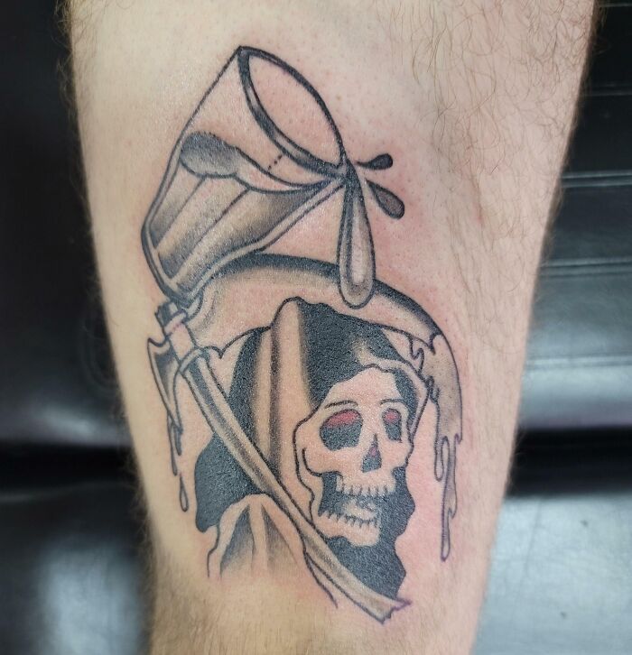 Funny tattoo of a grim reaper with a beer mug, adding humor to an arm design.