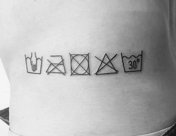 Funny tattoo of laundry symbols on skin for humorous body art.
