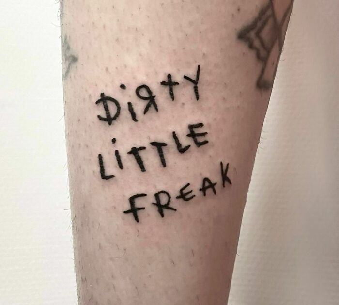 Funny tattoo on forearm with the words "Dirty Little Freak" in bold lettering.