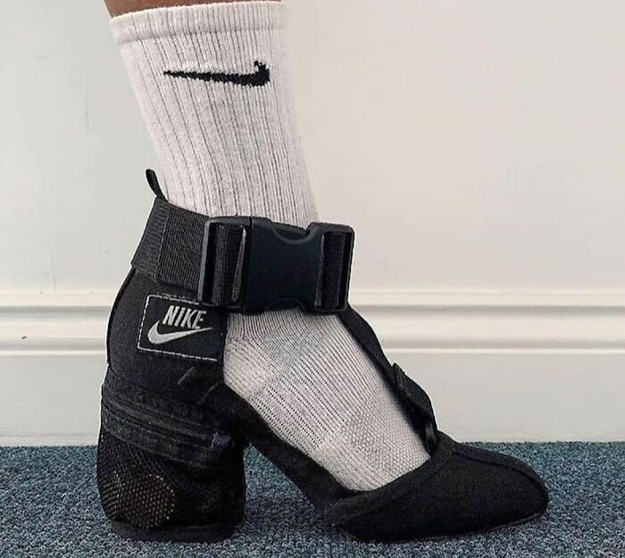 Weird shoe with a high heel and Nike logo, paired with a white sock.