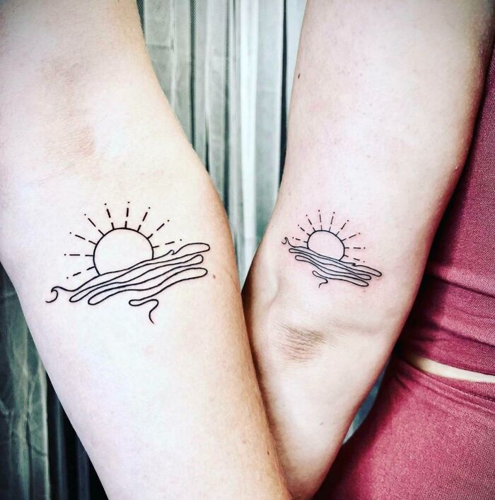 Matching sun and wave BFF tattoos on two arms, symbolizing friendship.