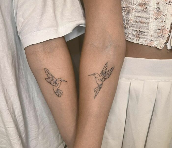 Two arms with matching hummingbird tattoos symbolizing BFF connection.