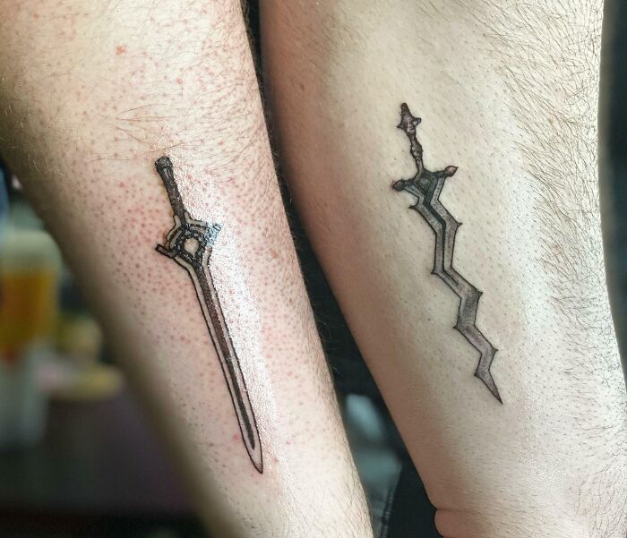 Two forearms with matching sword tattoos, illustrating BFF tattoo ideas for best friends.