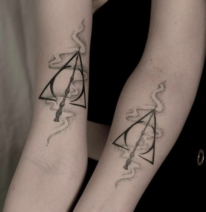 Matching BFF tattoos featuring magical symbols in black ink on forearms.
