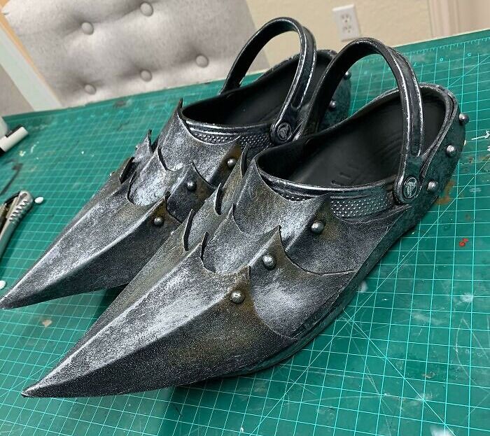 Weird shoes with pointed metallic design and rivet details on a green grid background.