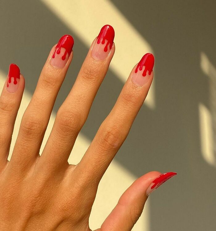 Hand with red drip nail art design, showcasing creative and trendy nail art ideas for stylish manicures.