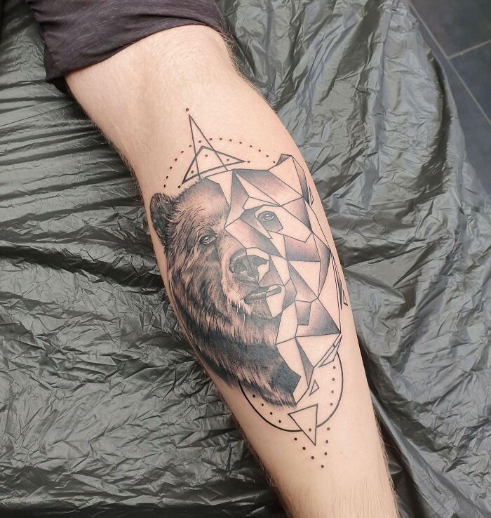 Geometric tattoo of a bear on a person's forearm, showcasing creative ink work and intricate design details.