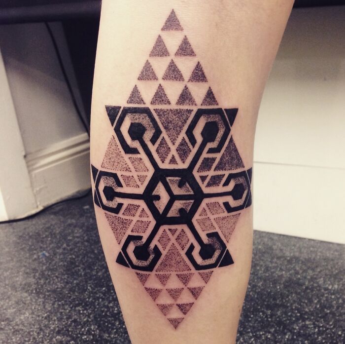 Geometric tattoo with intricate hexagonal and triangular patterns on a forearm, showcasing creative design.