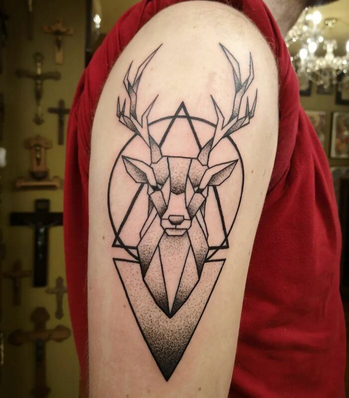 Geometric tattoo of a stag head with antlers on an arm, showcasing creative line art and shapes.