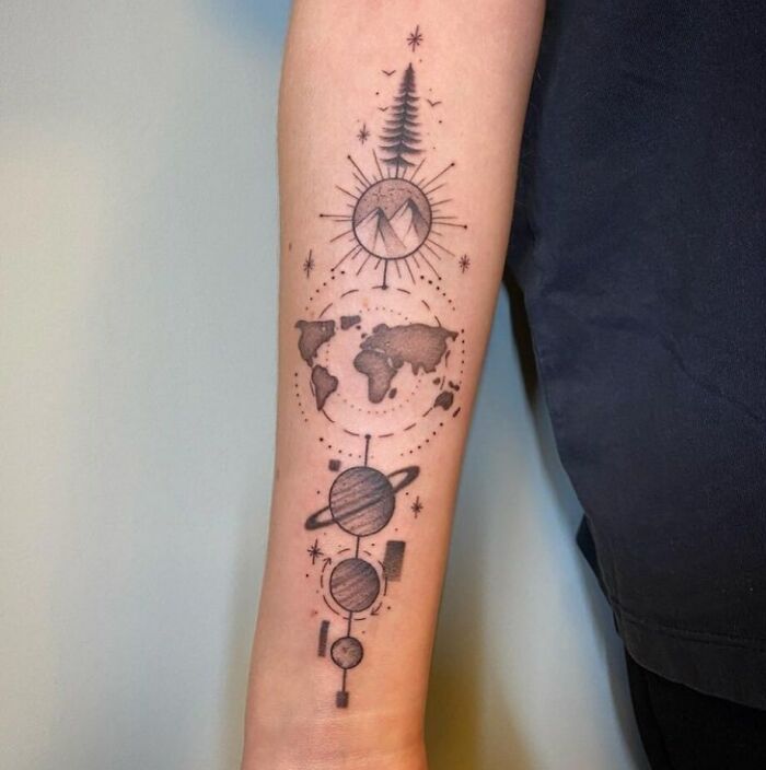 Geometric tattoo design featuring planets, a world map, and a tree, showcasing creative shapes and forms on forearm.