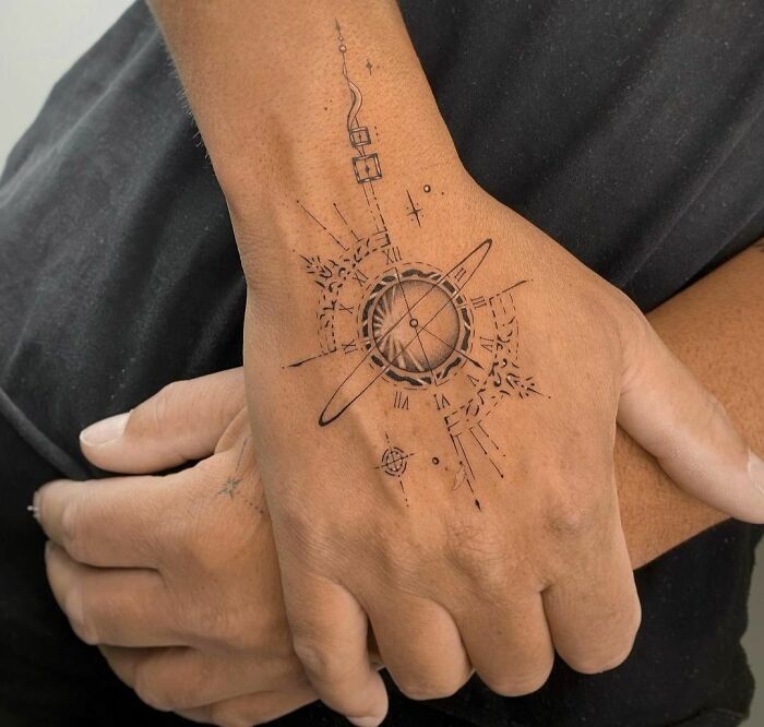 Geometric tattoo design on a hand featuring intricate circular and linear shapes, showcasing creativity and form.