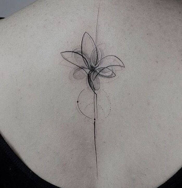 Geometric tattoo on back, featuring abstract flower design with fine lines and shapes.