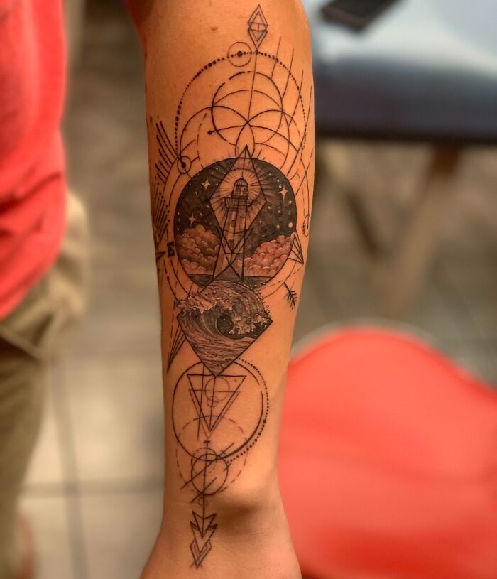 Geometric tattoo design on an arm, featuring intricate shapes and forms, showcasing creativity and artistry.