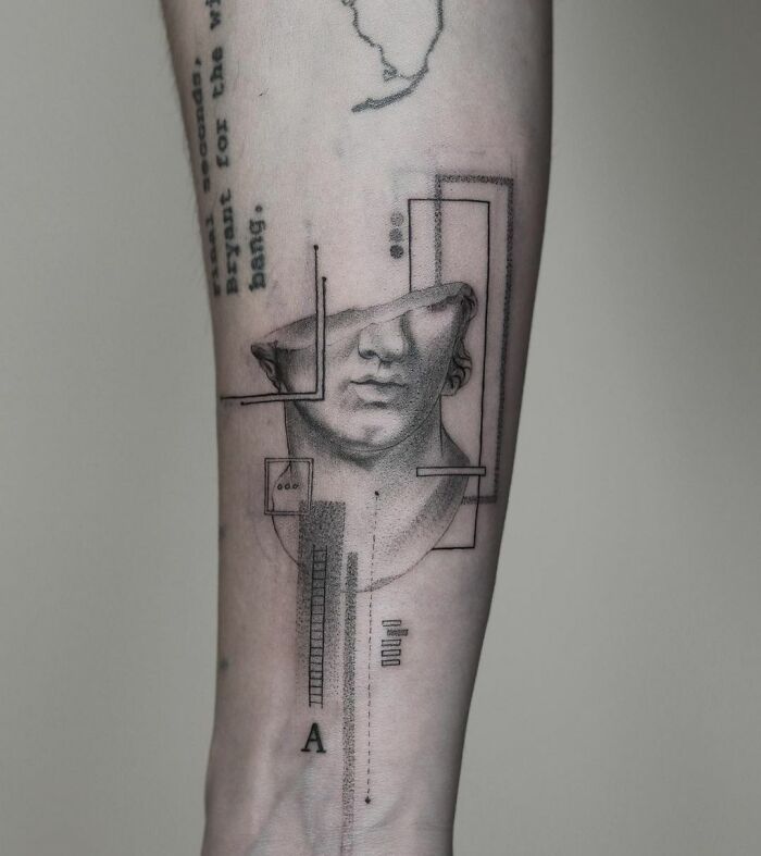 Geometric tattoo of an abstract face on an arm featuring lines and shapes.