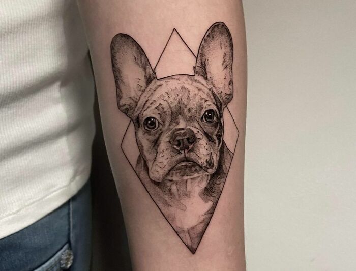 Geometric tattoo of a French bulldog on a person's arm.