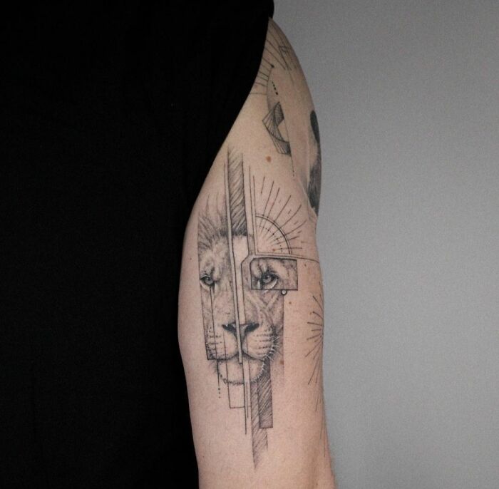 Geometric tattoo of a lion with abstract lines on an arm.