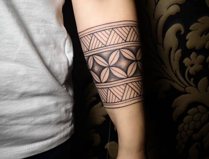 Geometric tattoo design on a person's forearm, featuring intricate black line patterns and circles.