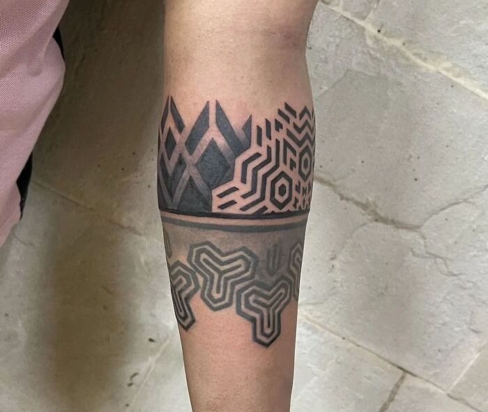 Geometric tattoos featuring intricate patterns on a forearm, showcasing bold and intricate designs.