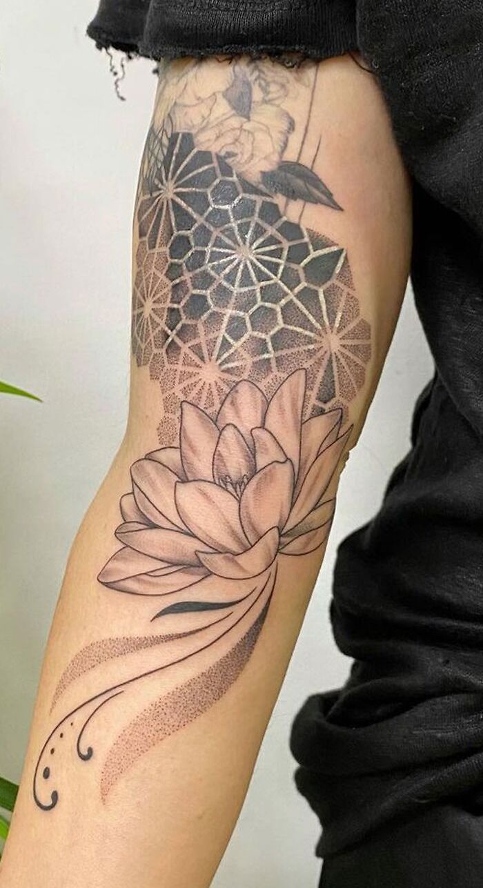 Geometric tattoo with a floral design and intricate patterns on a person's arm.