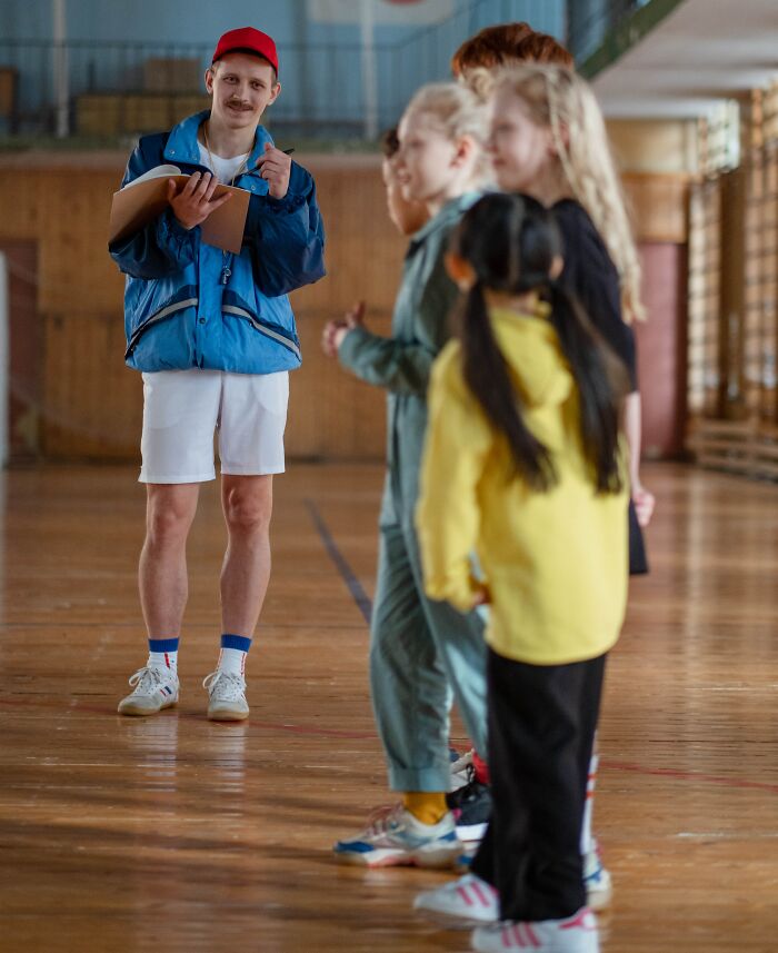 Physical Education Teacher Taking Notes On The Students 