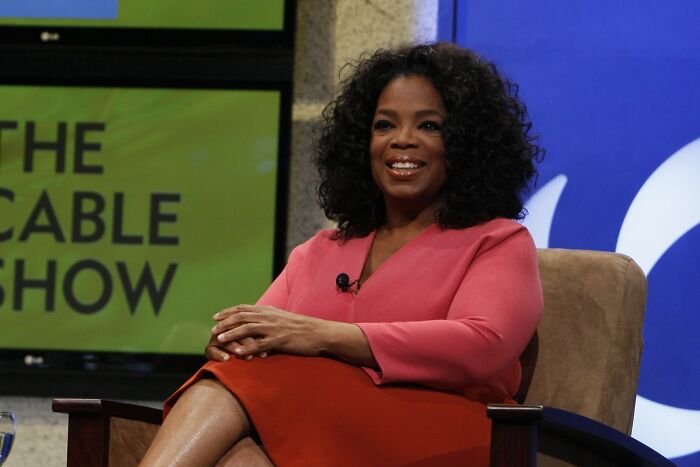 Oprah Winfrey seated on a chair during a talk show, representing celebrities who never married yet found love.