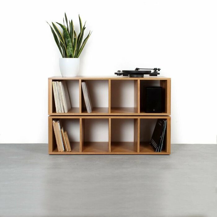 Wooden shelving unit with records and a plant, showcasing home organization ideas.