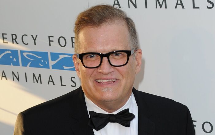 Drew Carey in a tuxedo smiling at an event, featured among celebrities who never married yet still found love.