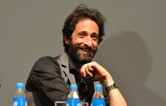 Adrien Brody smiling warmly while sitting at a panel, representing celebrities who never married yet found love.