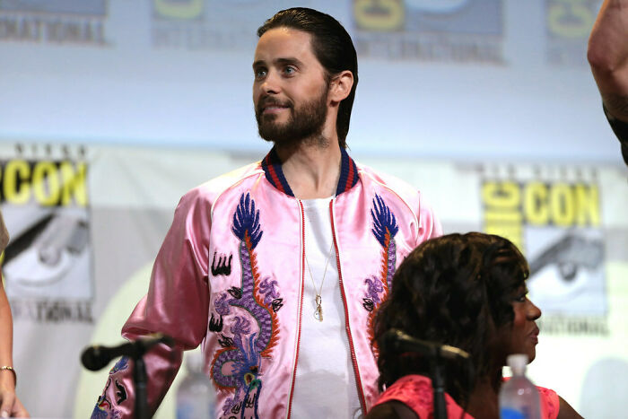 Jared Leto wearing a pink jacket at a panel event, representing celebrities who never married yet still found love.