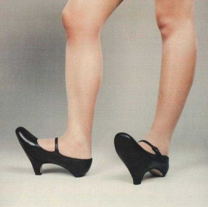 Unusual black shoes with inverted heels on display.