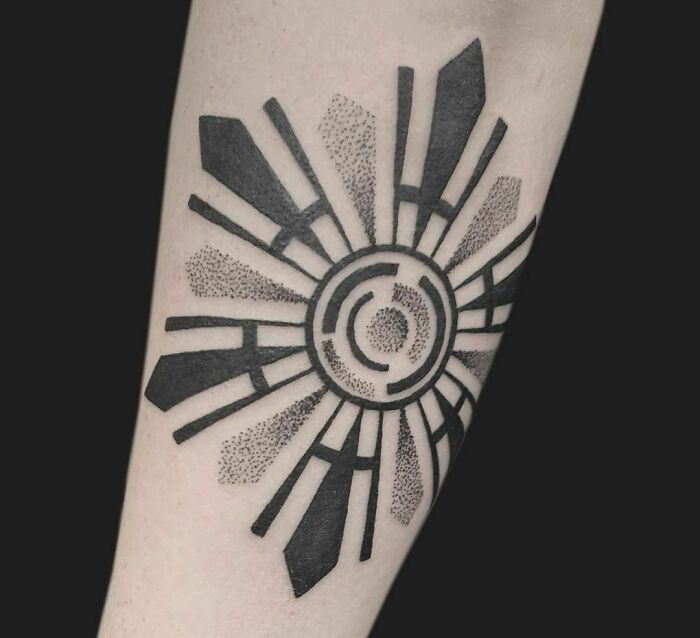 Geometric tattoo showcasing intricate shapes and forms in a circular pattern on forearm.