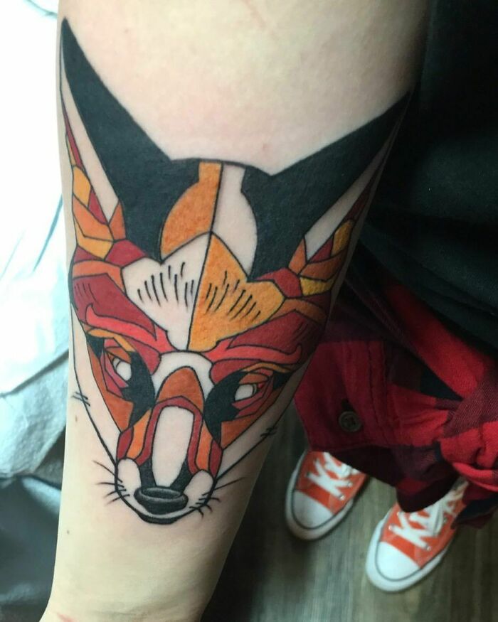 Geometric fox tattoo in vibrant colors on forearm, showcasing creativity in design.
