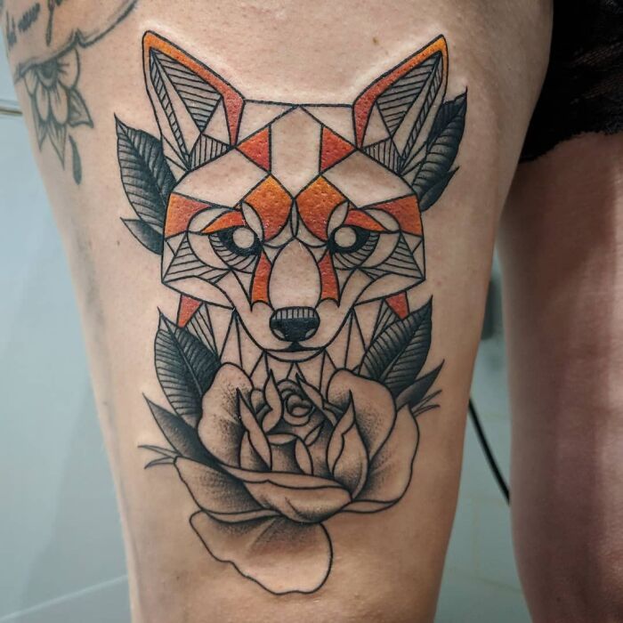 Geometric tattoo of a fox and rose design, featuring intricate patterns and bold colors on the thigh.