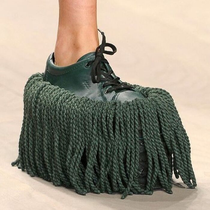 Green lace-up shoe with thick, mop-like fringe, showcasing weird shoe design.