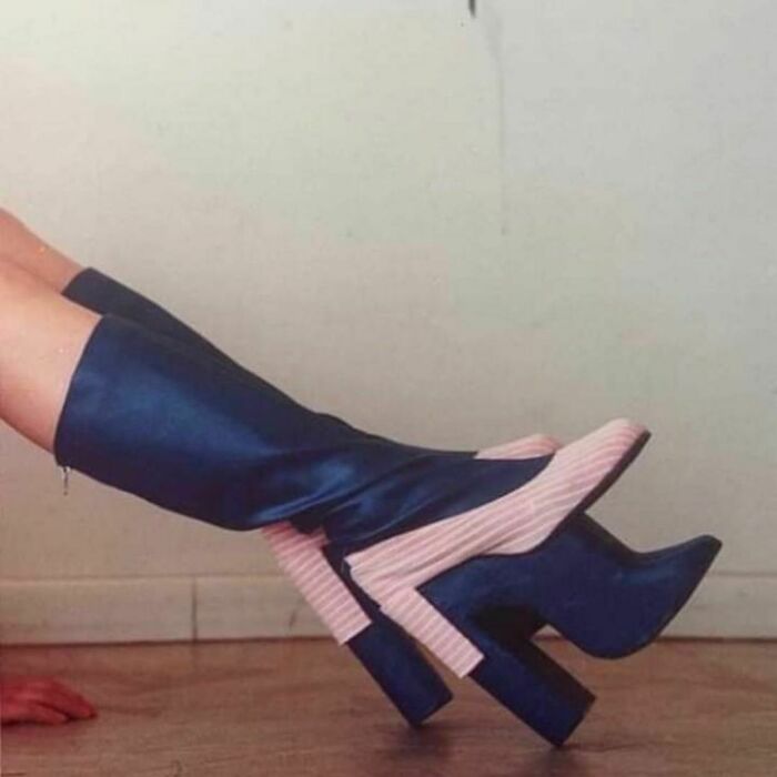 Unusual blue and pink high platform boots with a unique design on a wooden floor.