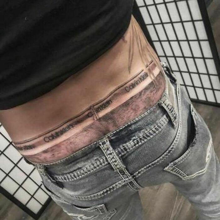 Tattoo of Calvin Klein waistband across lower back, showcasing a unique, questionable tattoo choice.