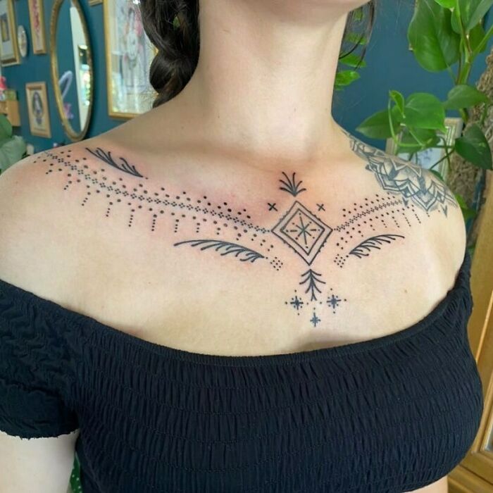 Geometric tattoo on upper chest featuring intricate lines and shapes, showcasing creative artistry.