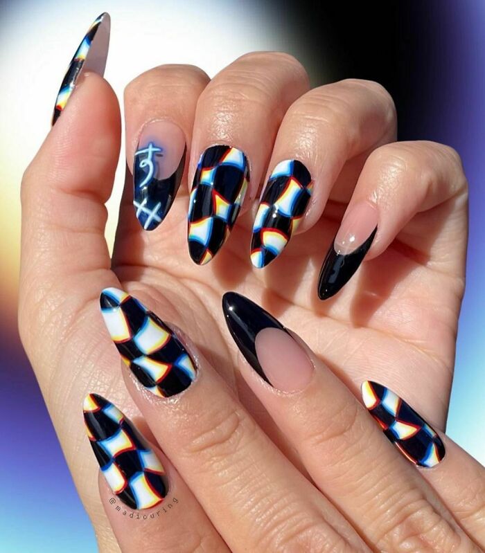 Abstract black and blue patterned nail art on long almond-shaped nails showcasing creative nail art ideas.