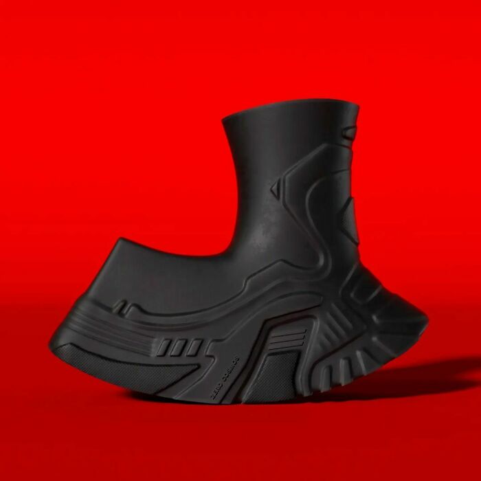 Unique black shoe with futuristic design on a red background.
